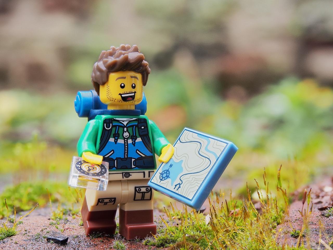 Yellow LEGO man in the role of an hiker, with a map and a compass
