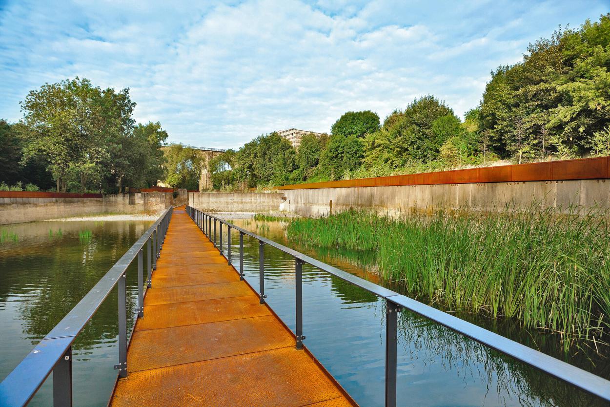 A long, metal footbridge above the water reservoir