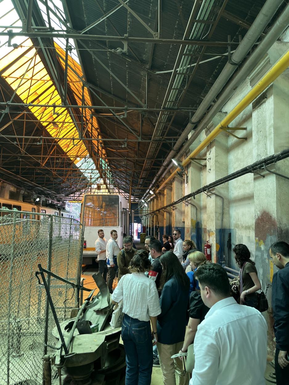 A group of people walking inside the tram depot building