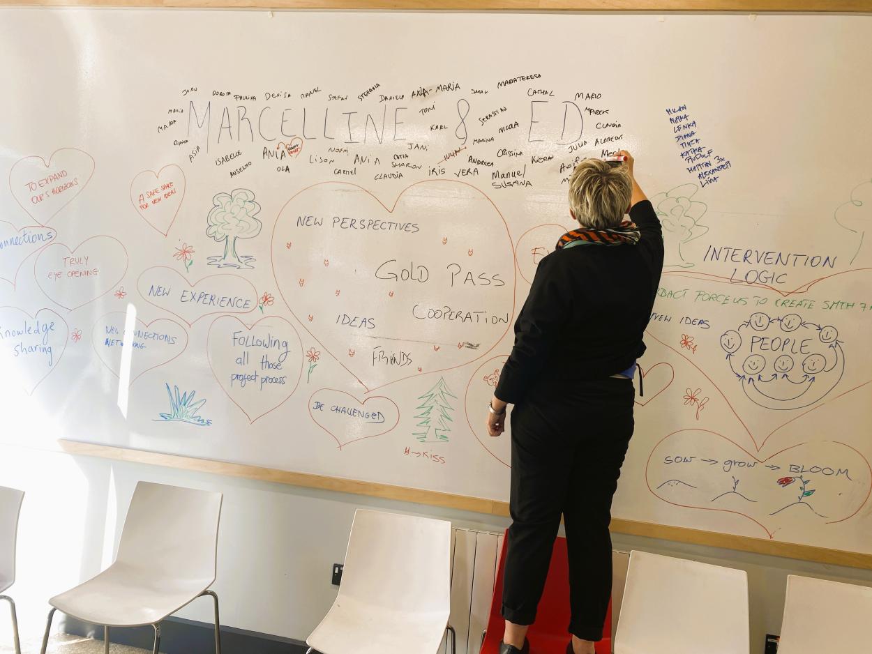 a woman writing on a whiteboard