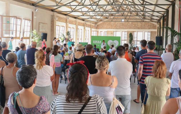 An indoor gathering or event taking place in a spacious, well-lit room with high ceilings and large windows. 