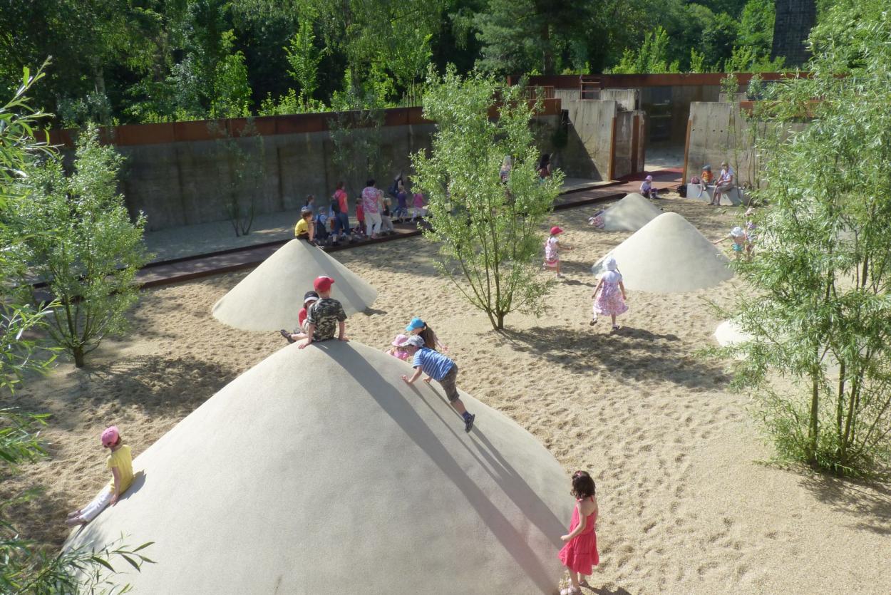 The playing area in sand with mounds with children climbing on them