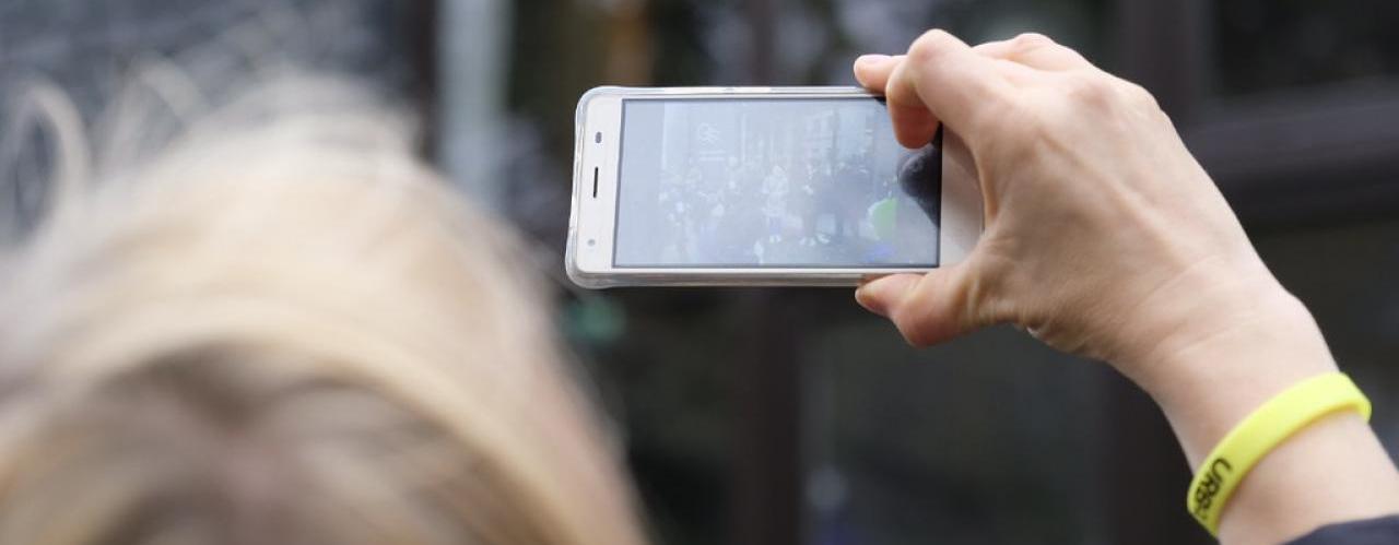 Women using her phone to take a picture at the Tallinn URBACT City Festival