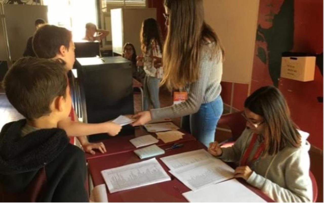 Civic engagement, with young people participating in the democratic process of voting.