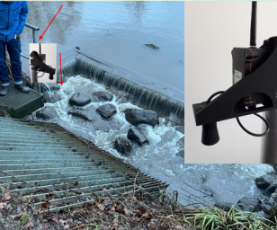 A water monitoring or measurement setup at a small dam or weir on a river. 