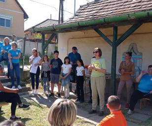 Group of people gathered in a garden to discuss.