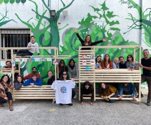 A group of people posing for a photo in front of a vibrant mural.