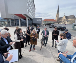 A group of people gathered outdoors in what appears to be an urban setting. 