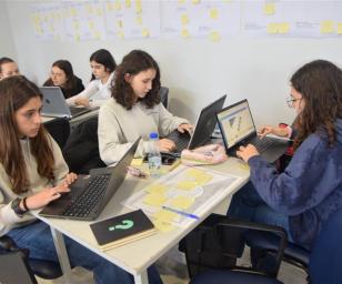 A group of young individuals, likely students, engaged in a collaborative learning or workshop setting. 