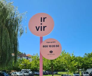 A signpost with two circular signs mounted on a pink pole.