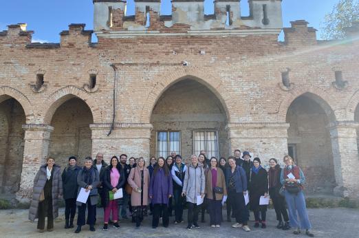 a group of people posing for a picture in from of an old building