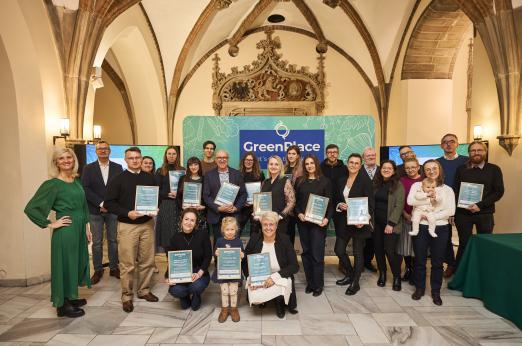 A conference participants posing for the picture in front of GreenPlace backdrop. 