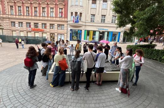 Hallgatói csoport Zágráb főterén a város bronz modellje felett beszélget