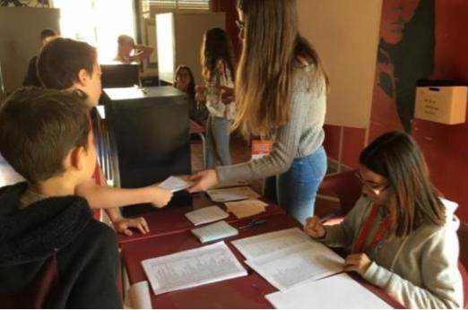 Civic engagement, with young people participating in the democratic process of voting.