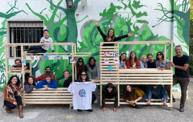 A group of people posing for a photo in front of a vibrant mural.