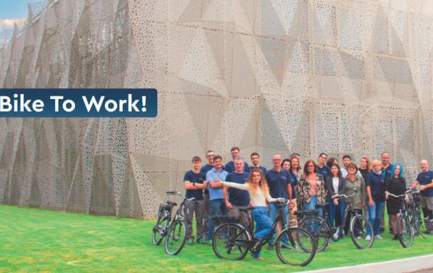 The people in the image are posing with bicycles, suggesting the theme of biking to work. 