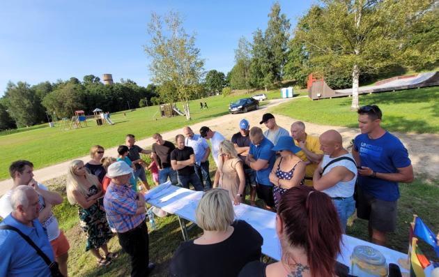 A group of people gathered outdoors in a park.