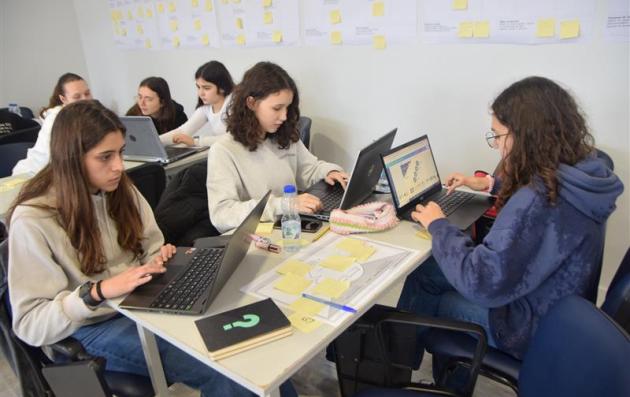 A group of young individuals, likely students, engaged in a collaborative learning or workshop setting. 