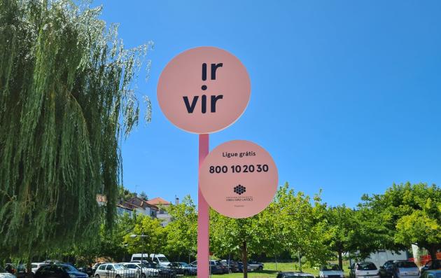 A signpost with two circular signs mounted on a pink pole.