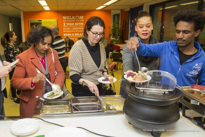 Four people plating food at a buffet