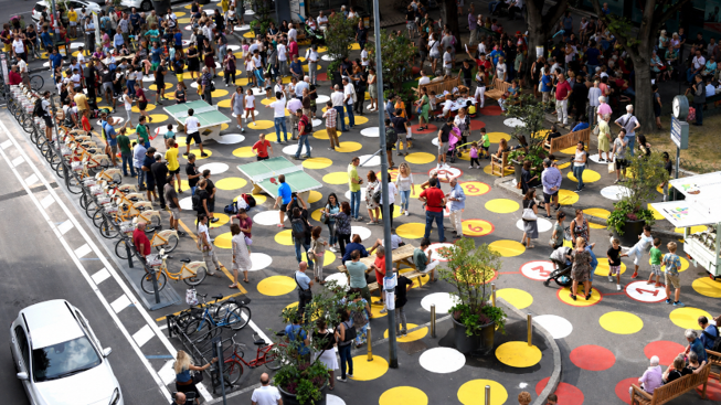 Milan streetscape filled with people with markings painted on the ground