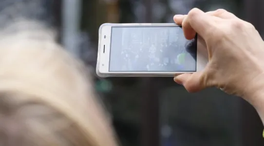 Women using her phone to take a picture at the Tallinn URBACT City Festival