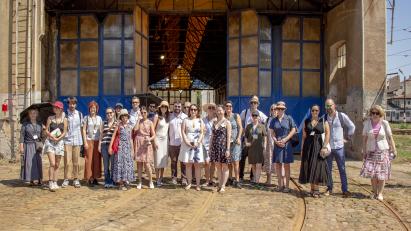 A group of people standing in front of the tram depot building