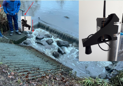 A water monitoring or measurement setup at a small dam or weir on a river. 