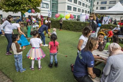 People sitting and talking, kids playing outside
