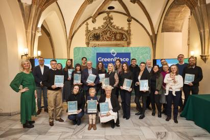 A conference participants posing for the picture in front of GreenPlace backdrop. 