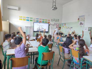 Children in classroom with raised hands