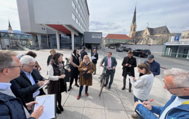 A group of people gathered outdoors in what appears to be an urban setting.